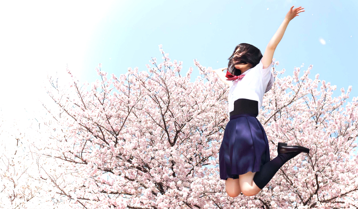 桜をバックに飛び上がる女子高生